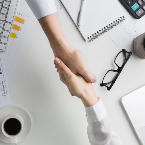 top-view-handshake-work-desk